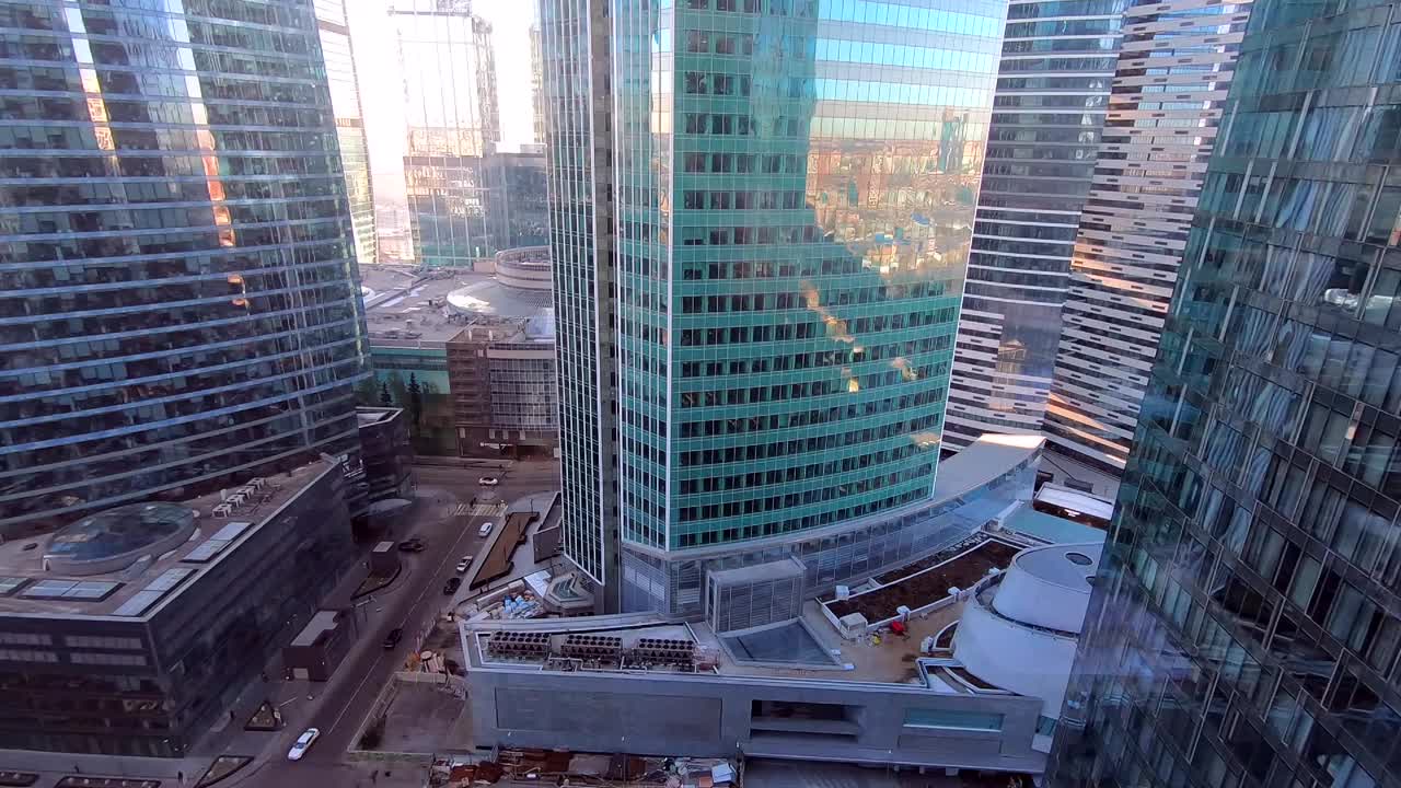 在一个晴朗的日子里，从工作场所的窗户到商业中心的现代化高层建筑的美丽景色，映衬着城市的蓝天视频素材