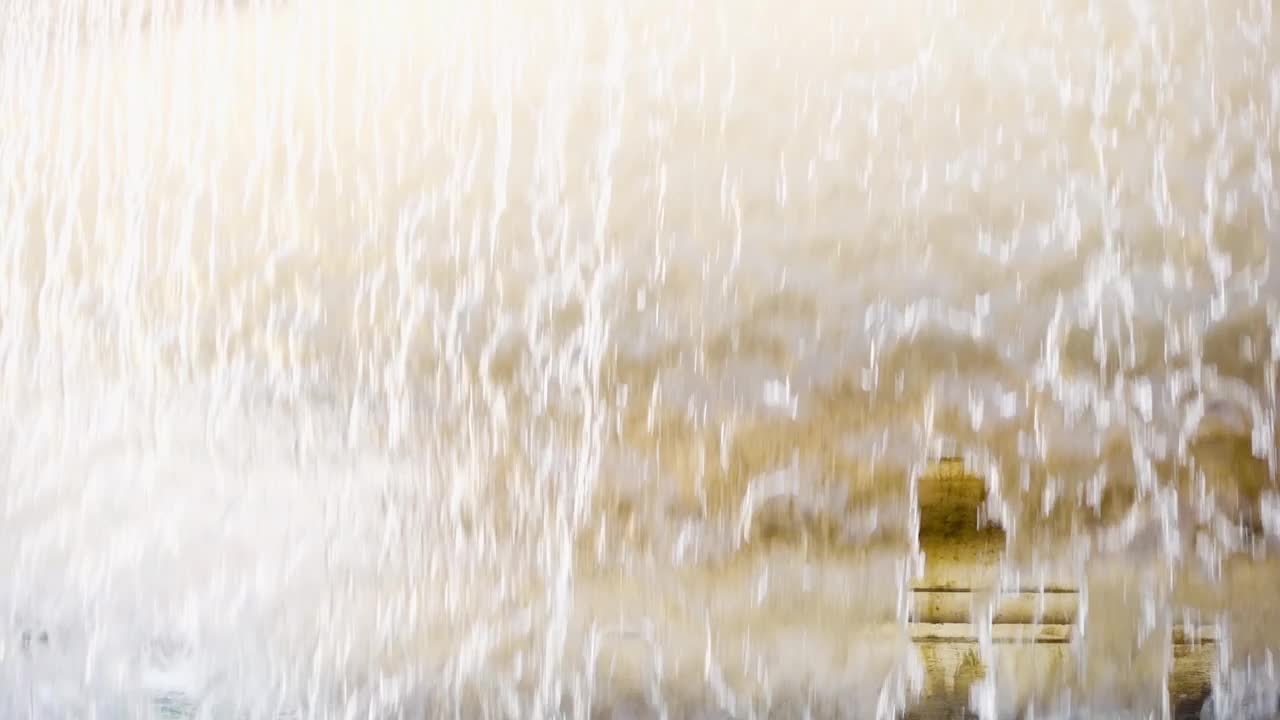 老黄大理石喷泉水幕的特写。透明的水流。夏天阳光灿烂的日子视频素材