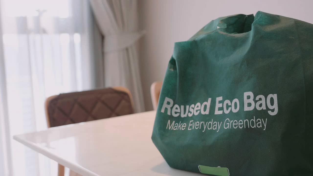桌子上的绿色可重复使用购物袋的特写视频下载
