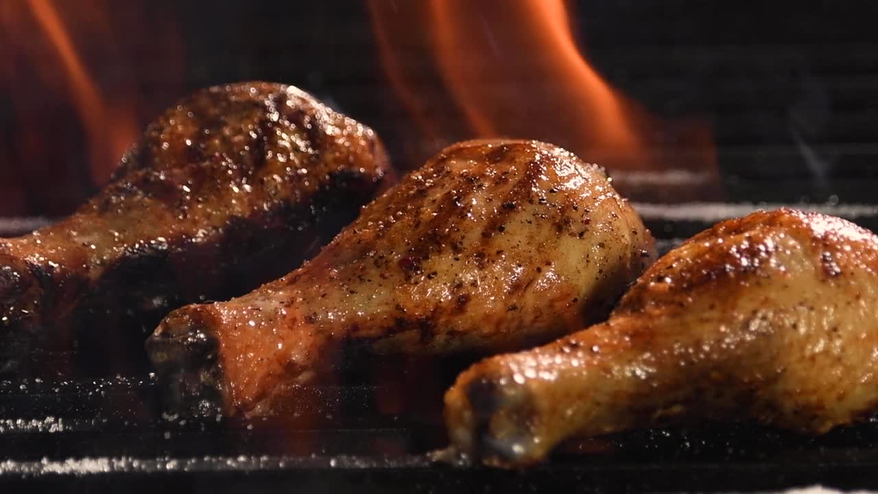 在燃烧的烤架上烤鸡腿视频素材