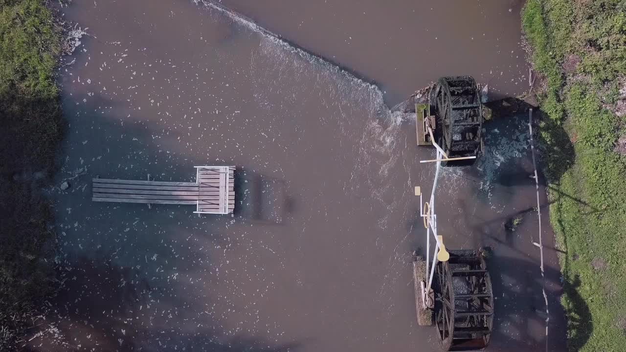 无人机在河上拍摄，河上有一个水磨，一个码头和一艘船视频下载