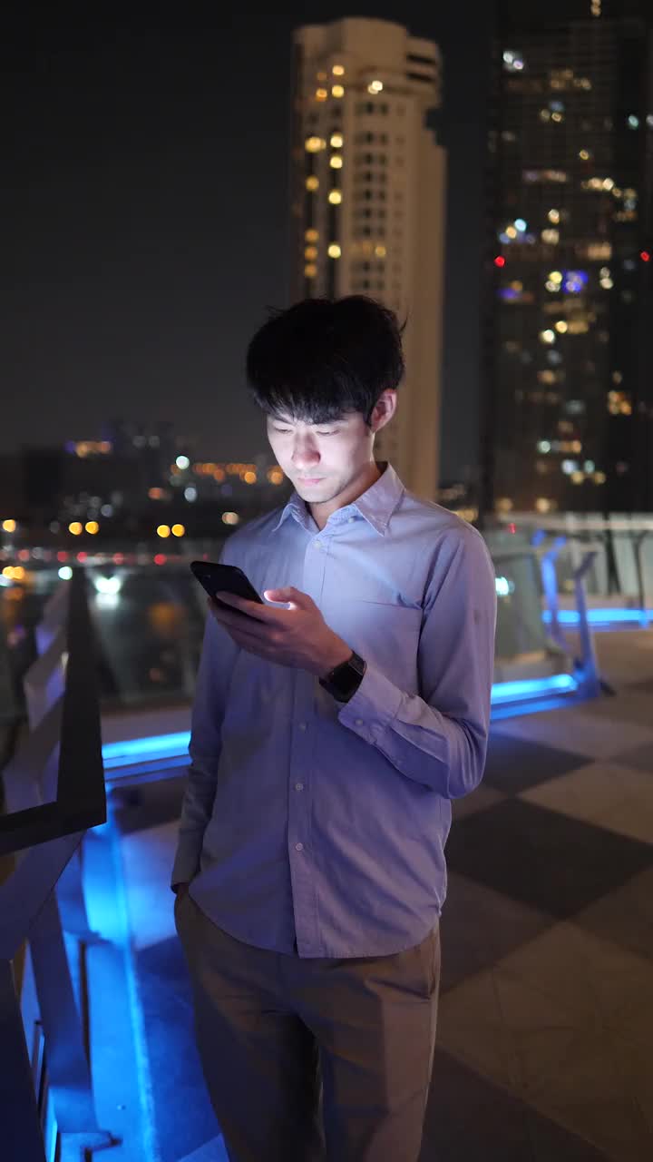 亚洲商人在晚上使用智能手机。视频素材