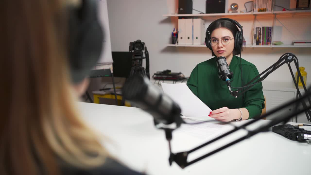 一名年轻女子在播音室为播客采访一位不认识的女嘉宾视频下载