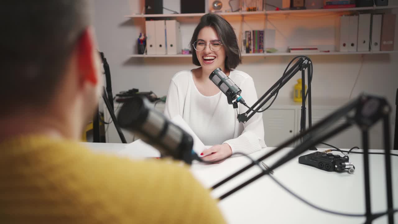 一个快乐的女人在一个播音室采访一个不认识的男嘉宾视频素材