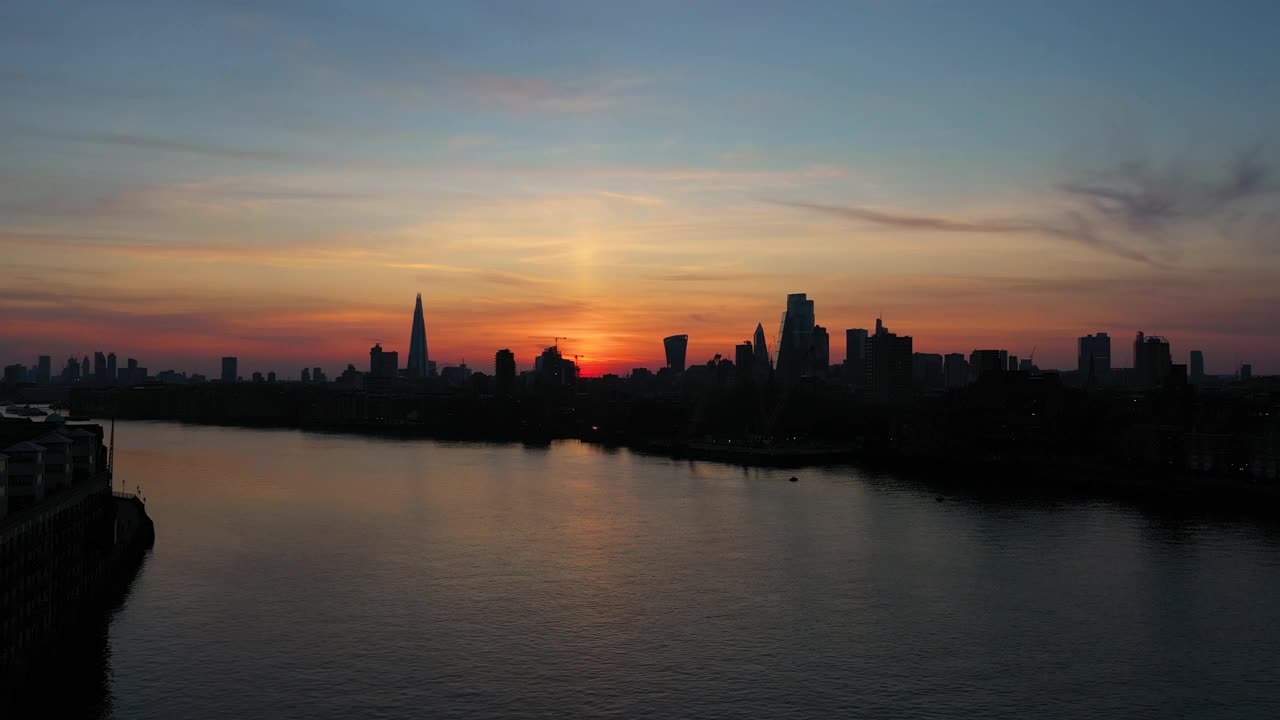 日落时泰晤士河上的伦敦金融商业区，高角度空中稳定拍摄视频素材