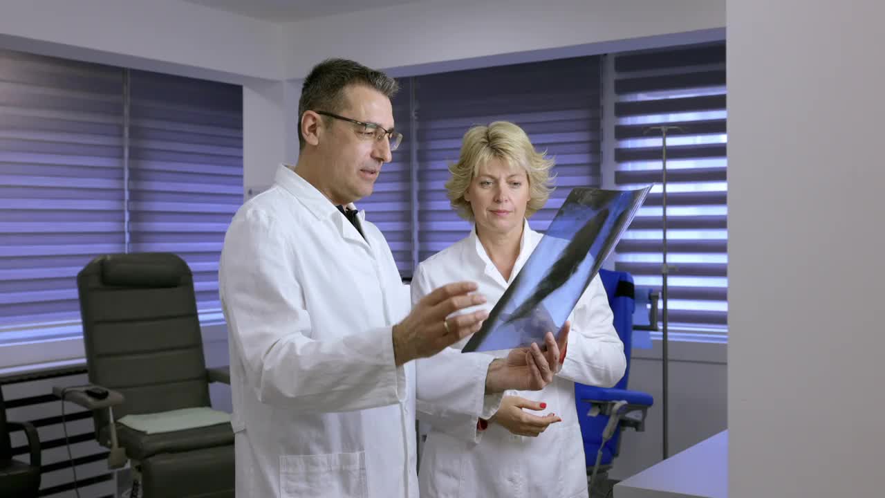 医生和他的女同事拿着x光片并同意条件视频下载