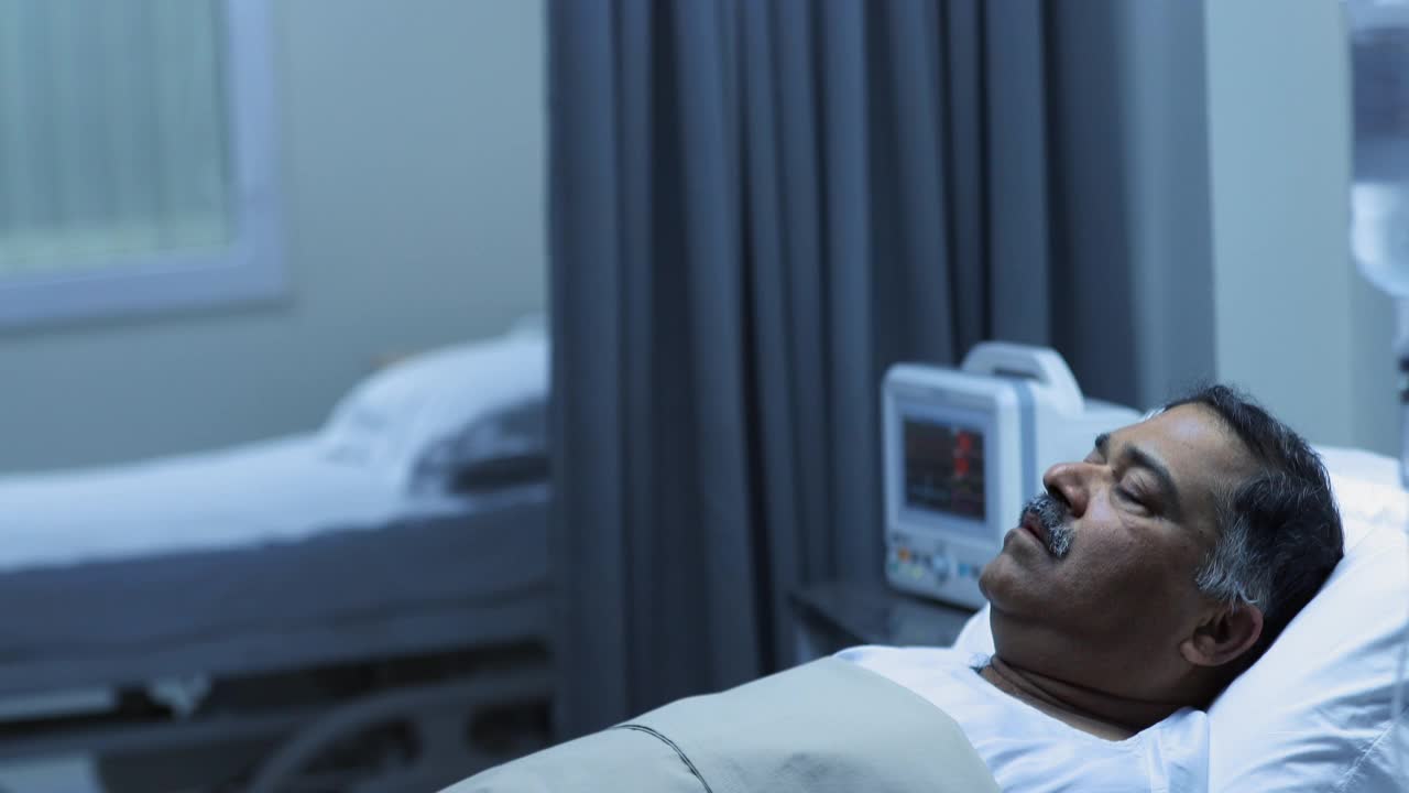 中等拍摄的生病的成熟男子呼叫护士时，躺在病床上视频下载