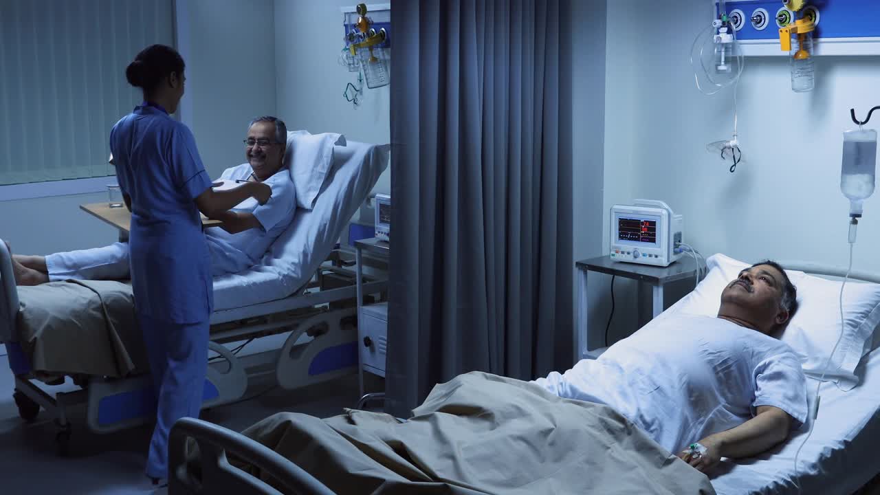 中等镜头的护士探望病人和书写在医院的剪贴板上视频下载
