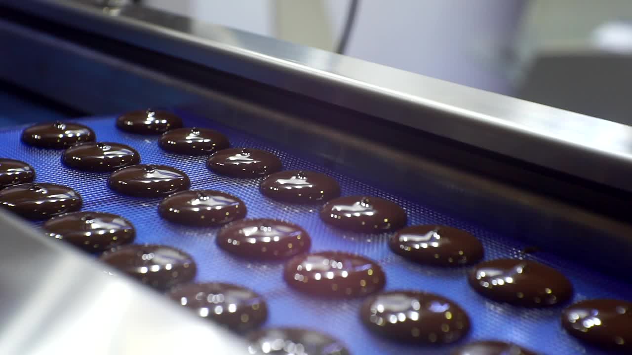 现代工作食品设备。巧克力的生产。工艺流程。巧克力液从机器中倒出来。特写镜头视频素材