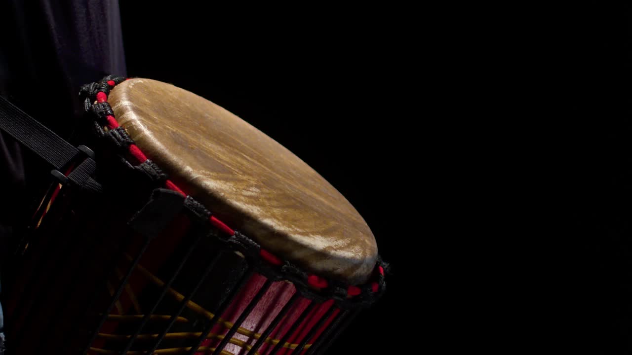一个黑人鼓手在录音室里有节奏地敲打着非洲鼓，特写。鼓乐器的概念视频素材