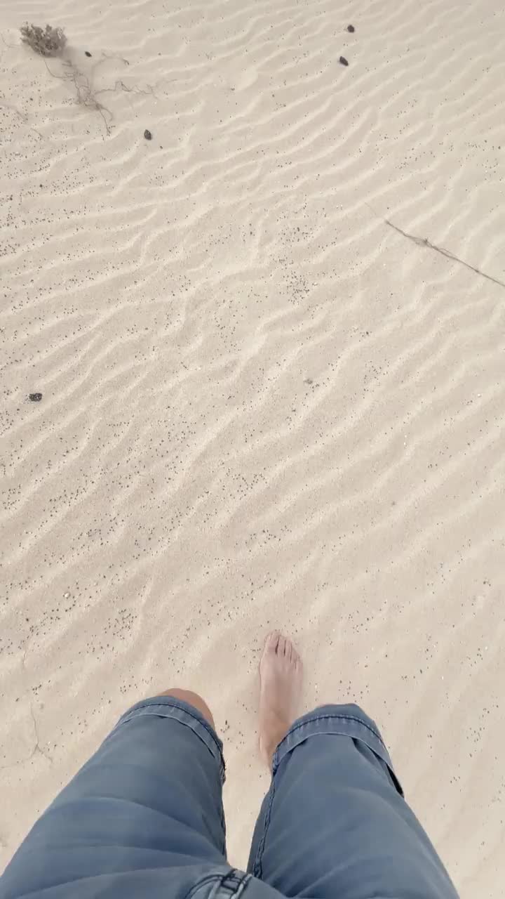 用手机拍摄的在西班牙富埃特文图拉岛白色沙丘上奔跑的垂直视频。视频下载