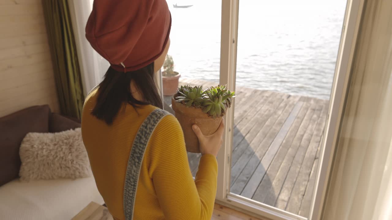 从家里搬盆栽到阳台的女人视频素材