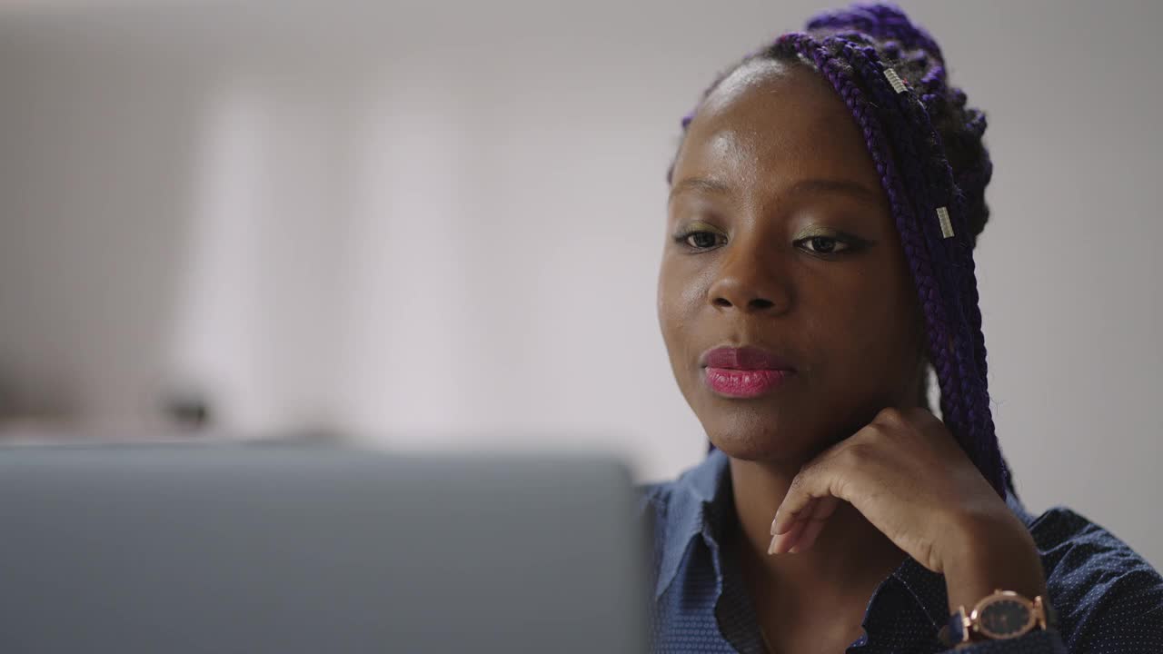 年轻的黑人女性正在用笔记本电脑进行在线视频通话，女性技术支持顾问，看着摄像头聊天视频素材