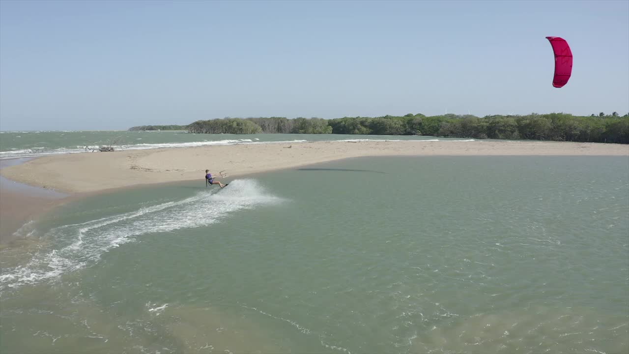 无人机的风筝板男人和女人和男人在一个风筝板附近的海滩。视频素材