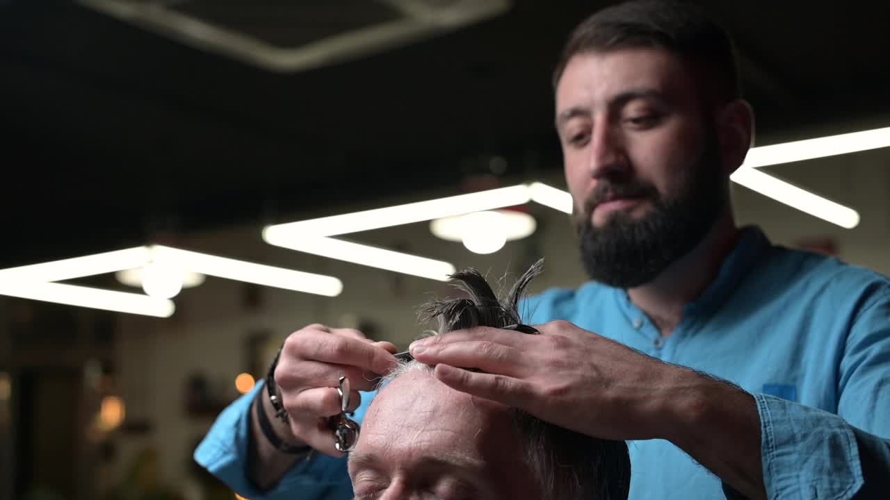 这是一位大师在理发店里拿着客户的头发的作品，特写。slowmo视频素材
