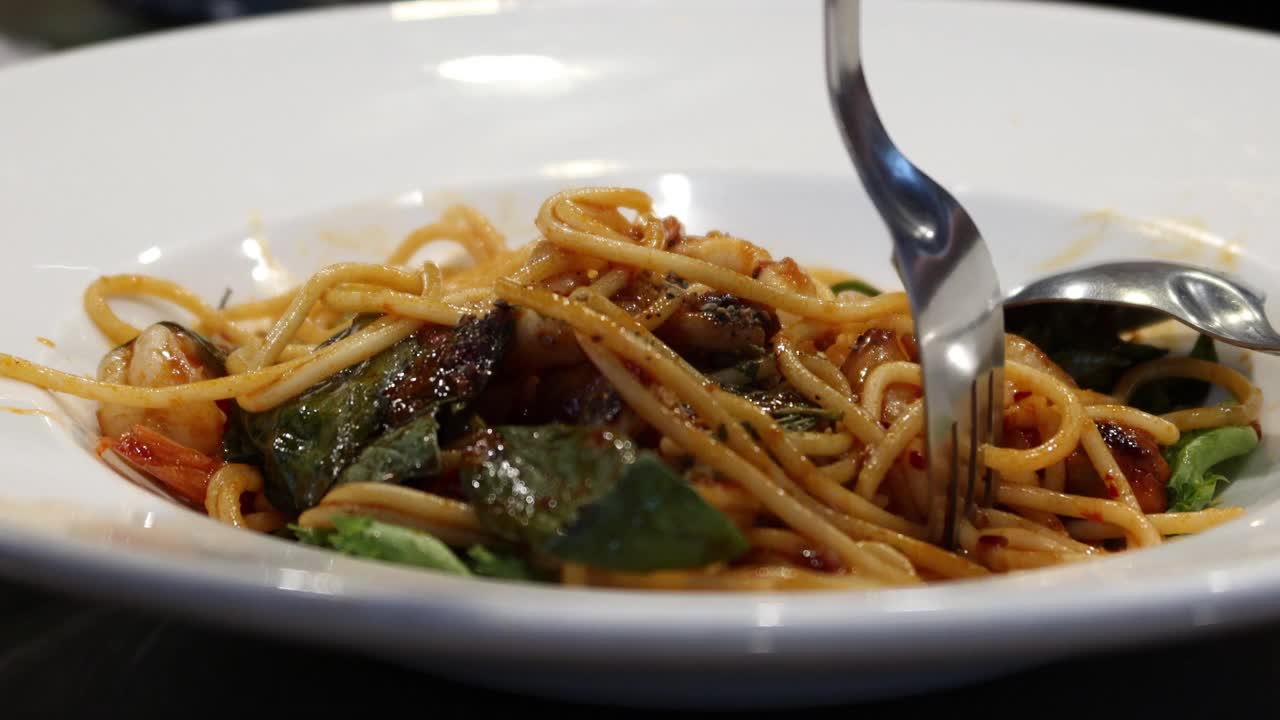 海鲜意大利面是在饭店用叉子卷着吃的视频素材