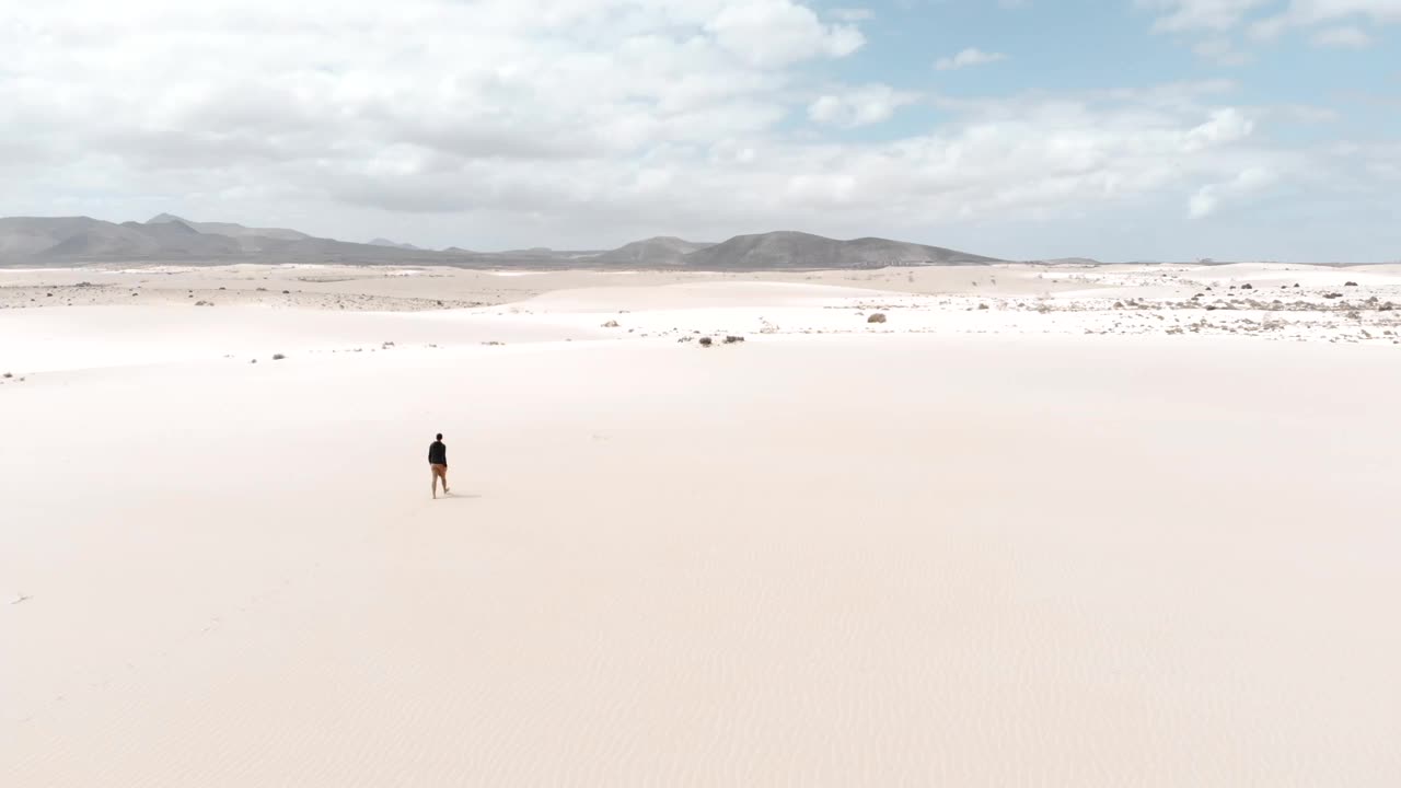一名男子在富埃特文图拉岛的沙丘沙漠中独自行走。西班牙。视频下载