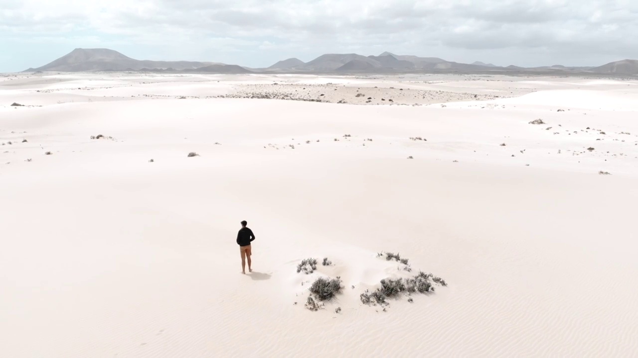 一名男子在富埃特文图拉岛的沙丘沙漠中独自沉思。西班牙。视频素材