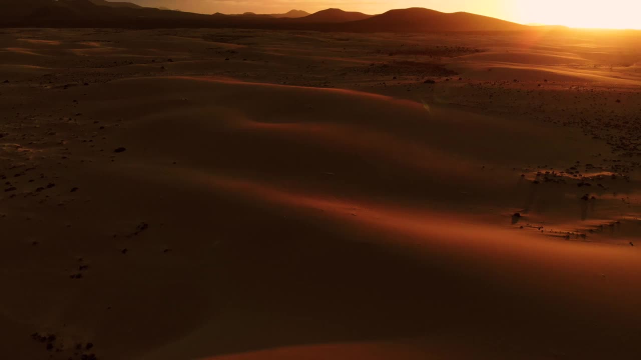 在富埃特文图拉岛，在沙漠沙丘上空的空中镜头与戏剧性的日落天空。西班牙。视频素材