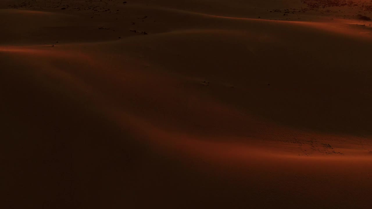 在富埃特文图拉岛，在沙漠沙丘上空的空中镜头与戏剧性的日落天空。西班牙。视频素材