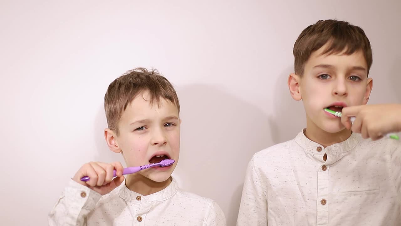 孩子们刷牙。两个小男孩在浴室里刷牙。视频素材