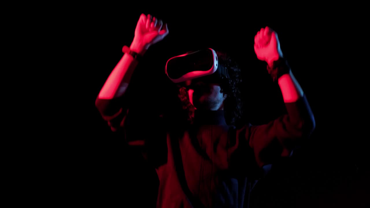 戴着VR头盔的男人在红蓝灯光下跳舞，网上派对视频素材