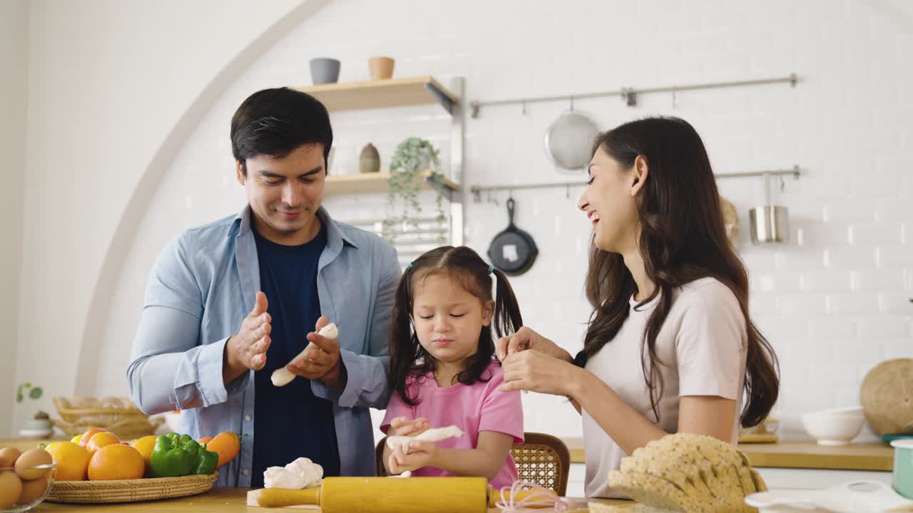 美丽可爱的家庭在一起做饭在厨房里玩得很开心。视频素材