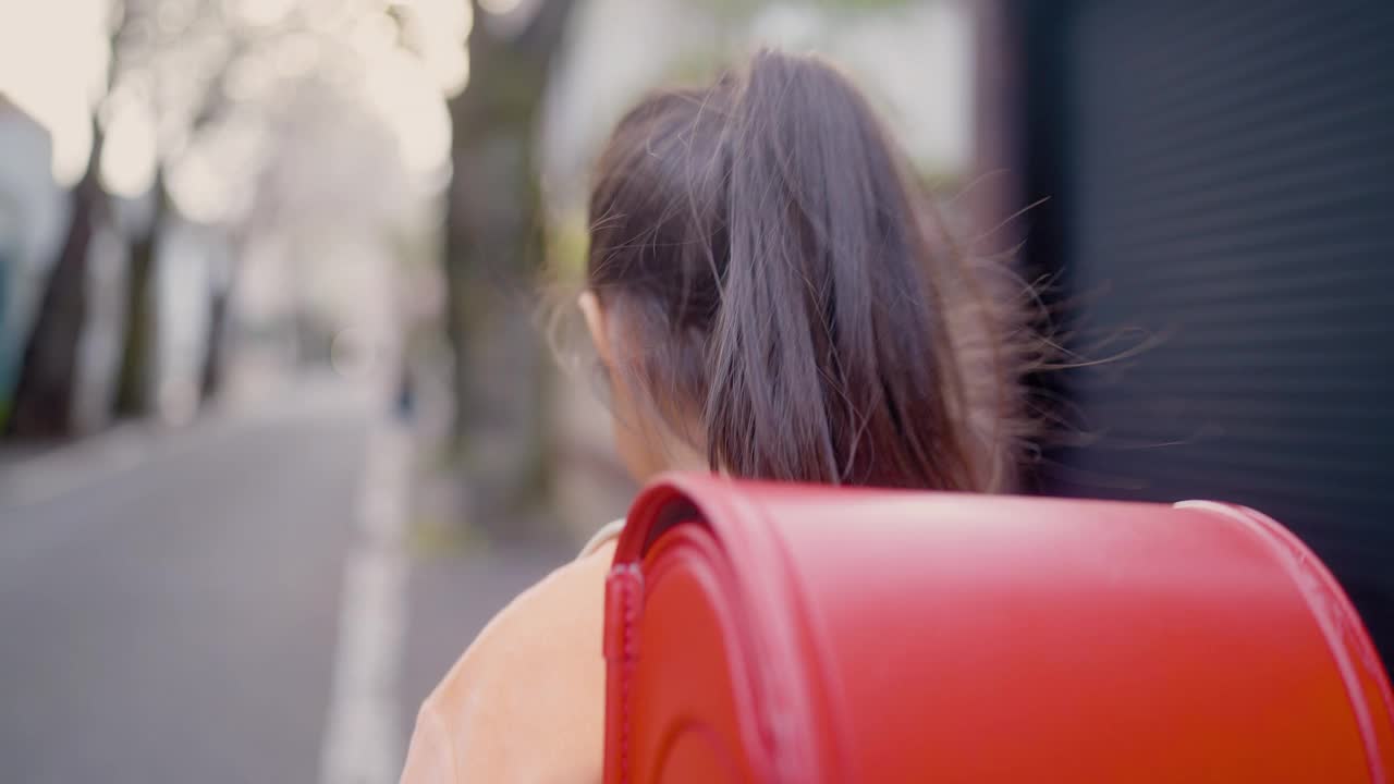 小日本女学生在住宅区樱花树下步行上学视频素材