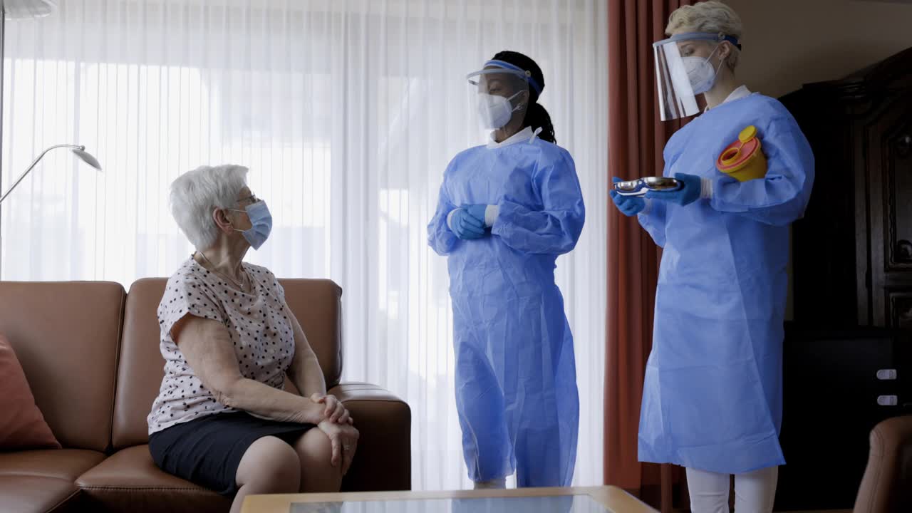 一线工作人员在老年妇女家中接种疫苗视频素材