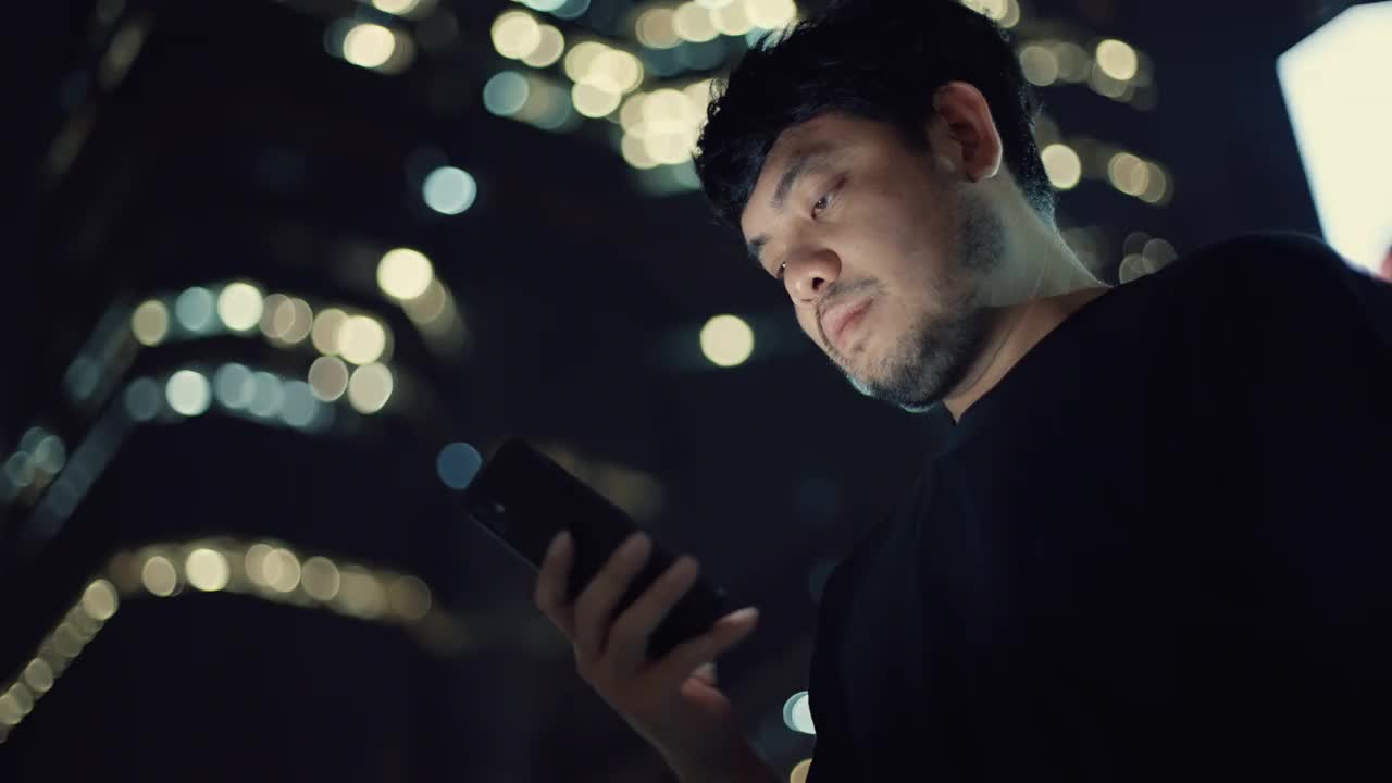 男人晚上在城市里用智能手机视频素材