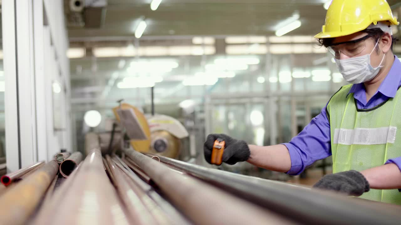 工厂工人戴着安全帽在金属钢上工作视频素材