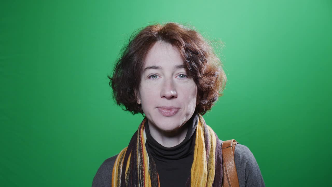 腰上的肖像微笑成熟的女人在绿色色彩的关键背景视频下载