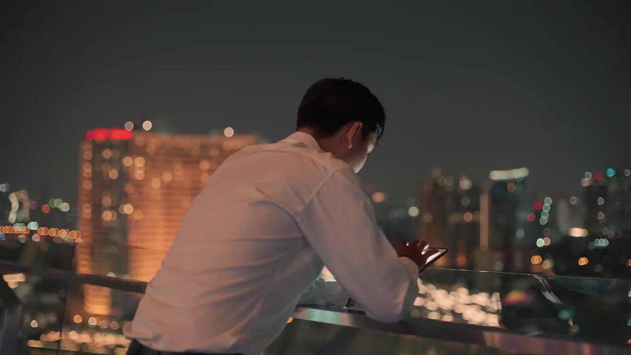 亚洲人晚上在城市里使用手机视频素材