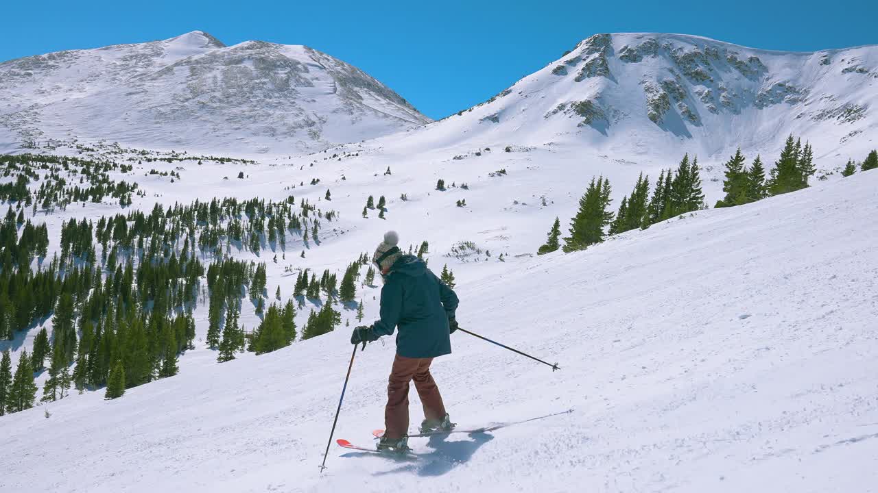 从陡峭的山上滑下来，慢动作，远处的雪山山峰如画视频下载