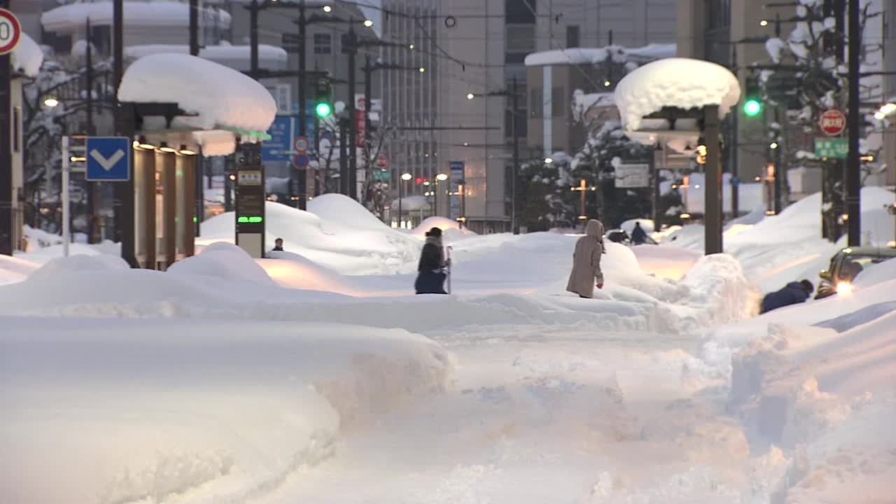 日本富山，大雪中穿过马路的人们视频下载