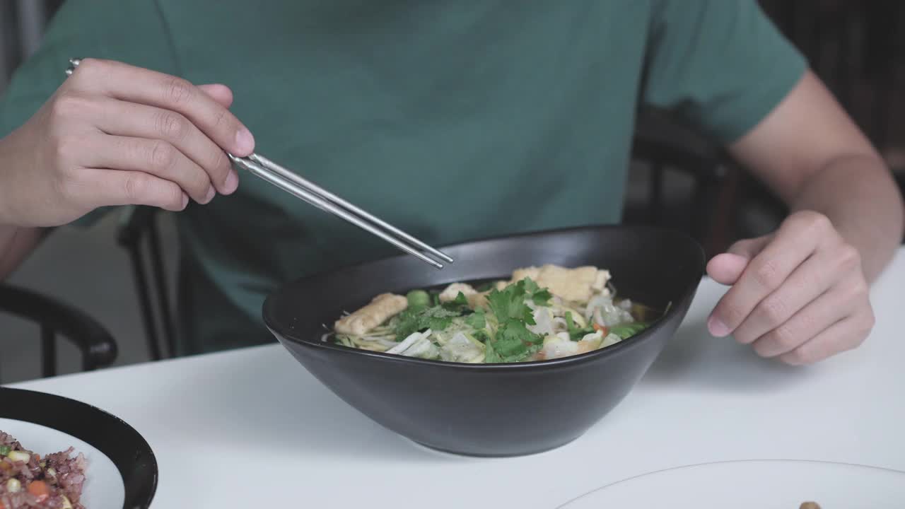 亚洲男子吃混合蔬菜素食拉面视频素材