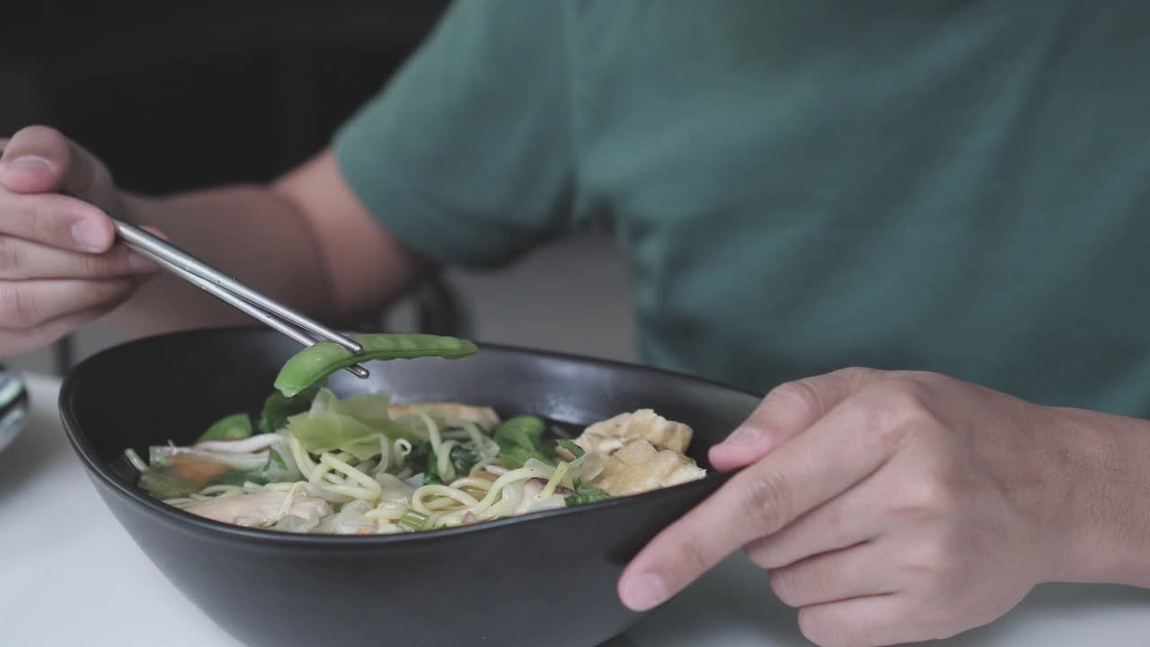 一名亚洲男子正在吃混合蔬菜素食拉面视频素材