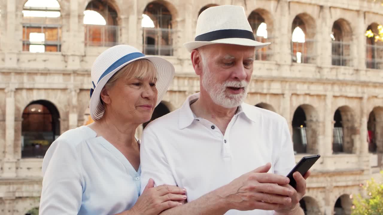 在罗马斗兽场附近，老年旅行者的幸福家庭通过手机messenger应用程序进行视频聊天视频下载