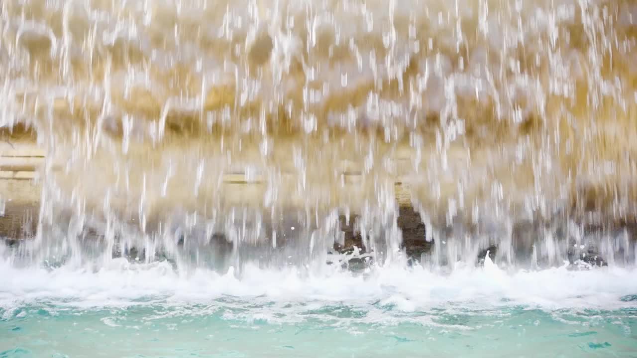 老黄大理石喷泉水幕的特写。透明的水流。夏天阳光灿烂的日子视频下载