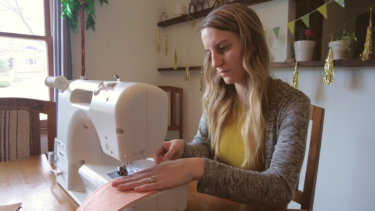 一个年轻的千禧一代女性用一台缝纫机制作4K视频的DIY项目视频下载