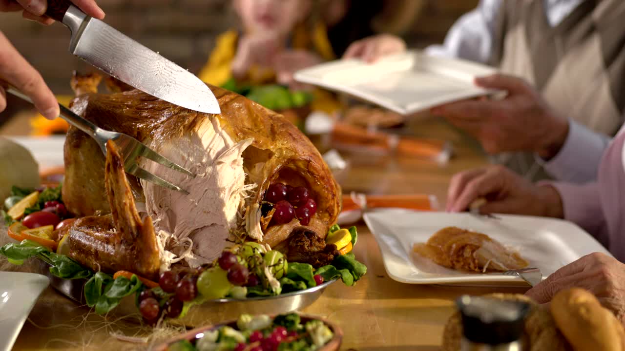 人们在感恩节晚餐上切白肉。视频下载