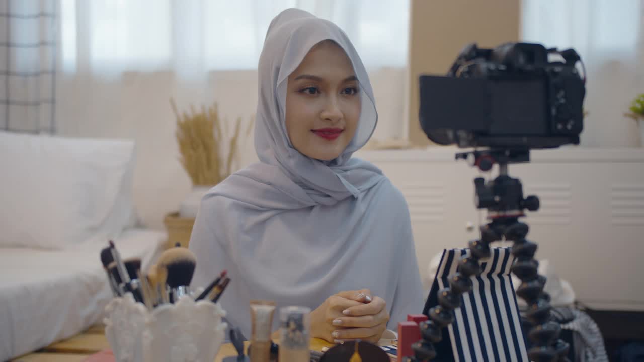 年轻的亚洲穆斯林女性美容影响博主录制视频与化妆品视频下载
