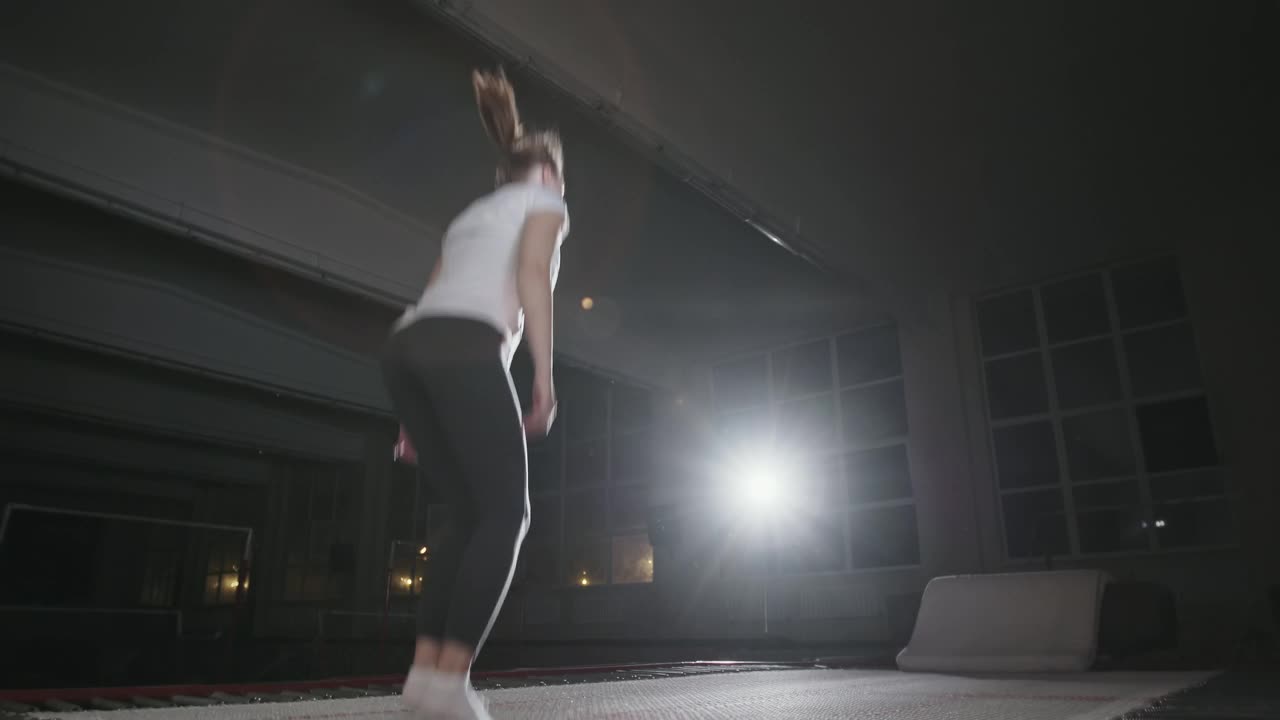 2019年9月29日，乌克兰，Ternopil:女子体操运动员穿着运动服在蹦床上表演右翻跳跃视频下载