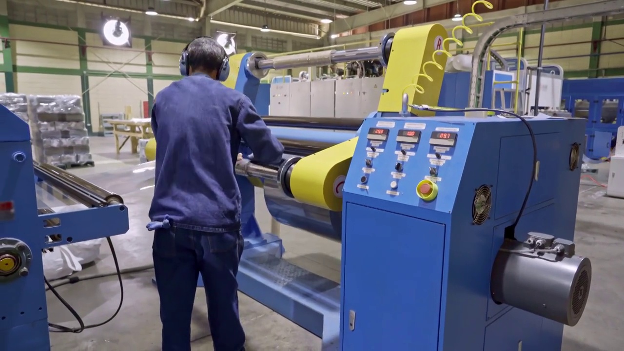 在层压板塑料制造回收生产线上更换层压板辊的西班牙男性工人视频下载