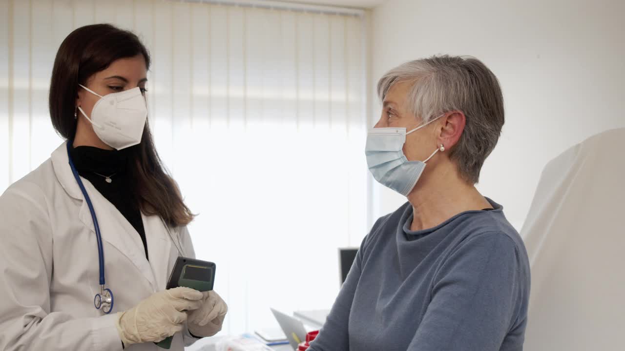 一名护士为一位成年女性测量体温的慢动作视频视频下载