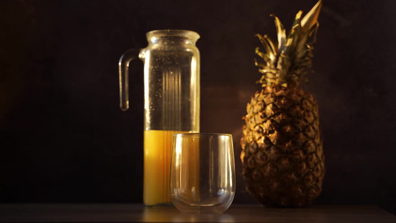菠萝、水果和果汁装在双层玻璃杯中。将热带果汁倒入玻璃杯中。视频下载