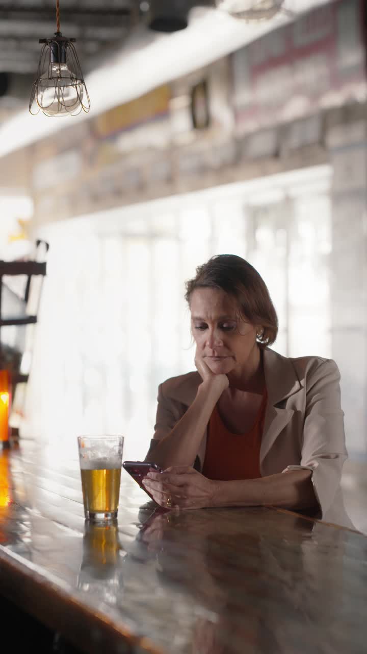 一个自信的女人坐在酒吧里看着镜头视频素材