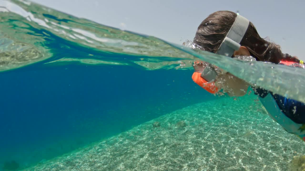 女孩浮潜在热带海洋的水下视频素材