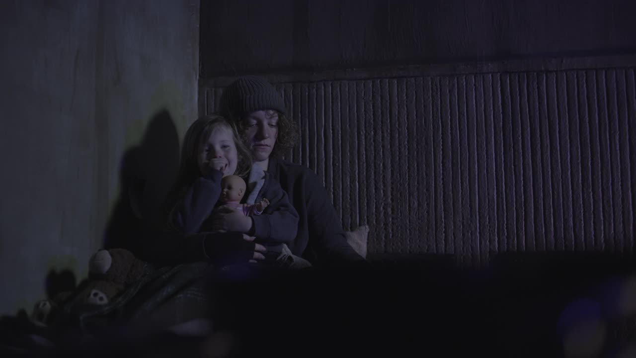 美国犹他州雪松山，警灯闪烁，一名妇女躺在地板上的床垫上安抚女儿和狗视频素材