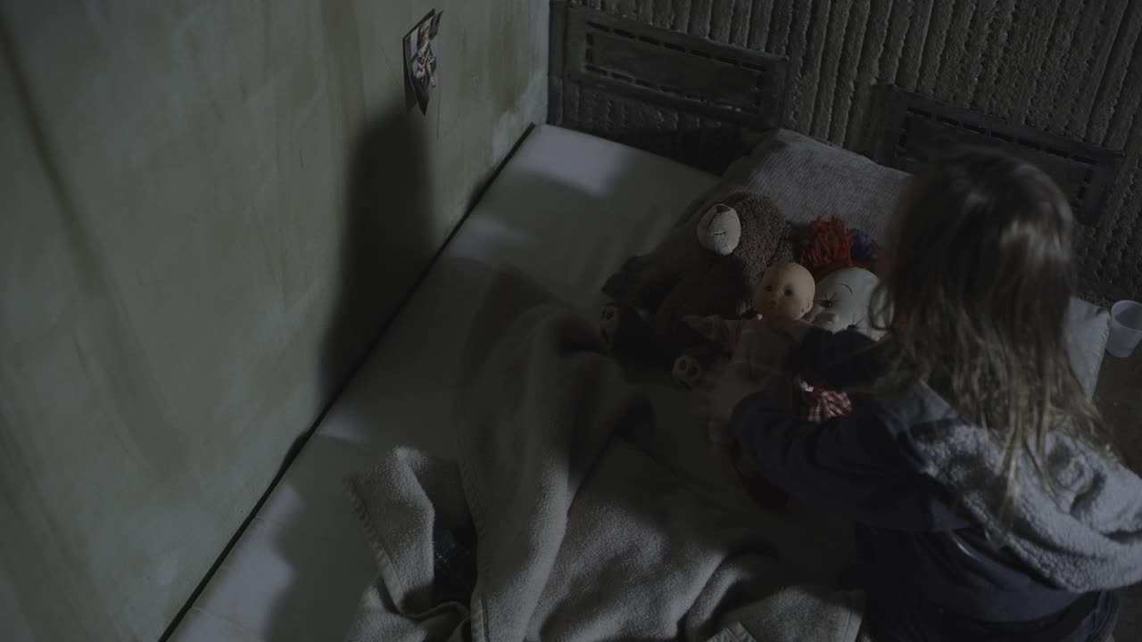 高角度的女孩跪在床垫上覆盖娃娃和泰迪熊与毯子/雪松山，犹他州，美国视频素材